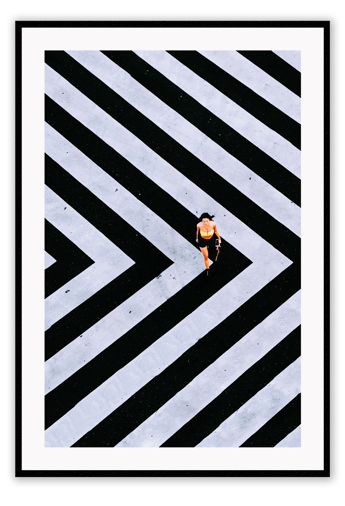 An urban wall art with an aerial view of a lady walking on black and white street crossing stripes