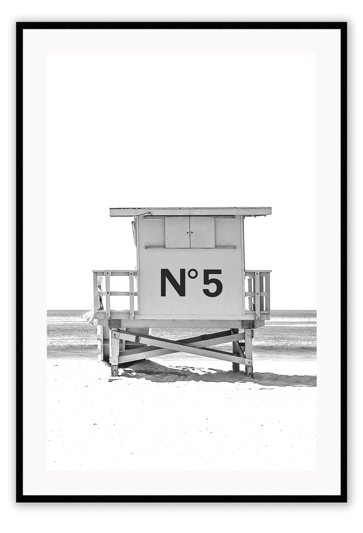 A black and white fashion wall art with black Chanel N5 fashion label on a beach cabin minimal