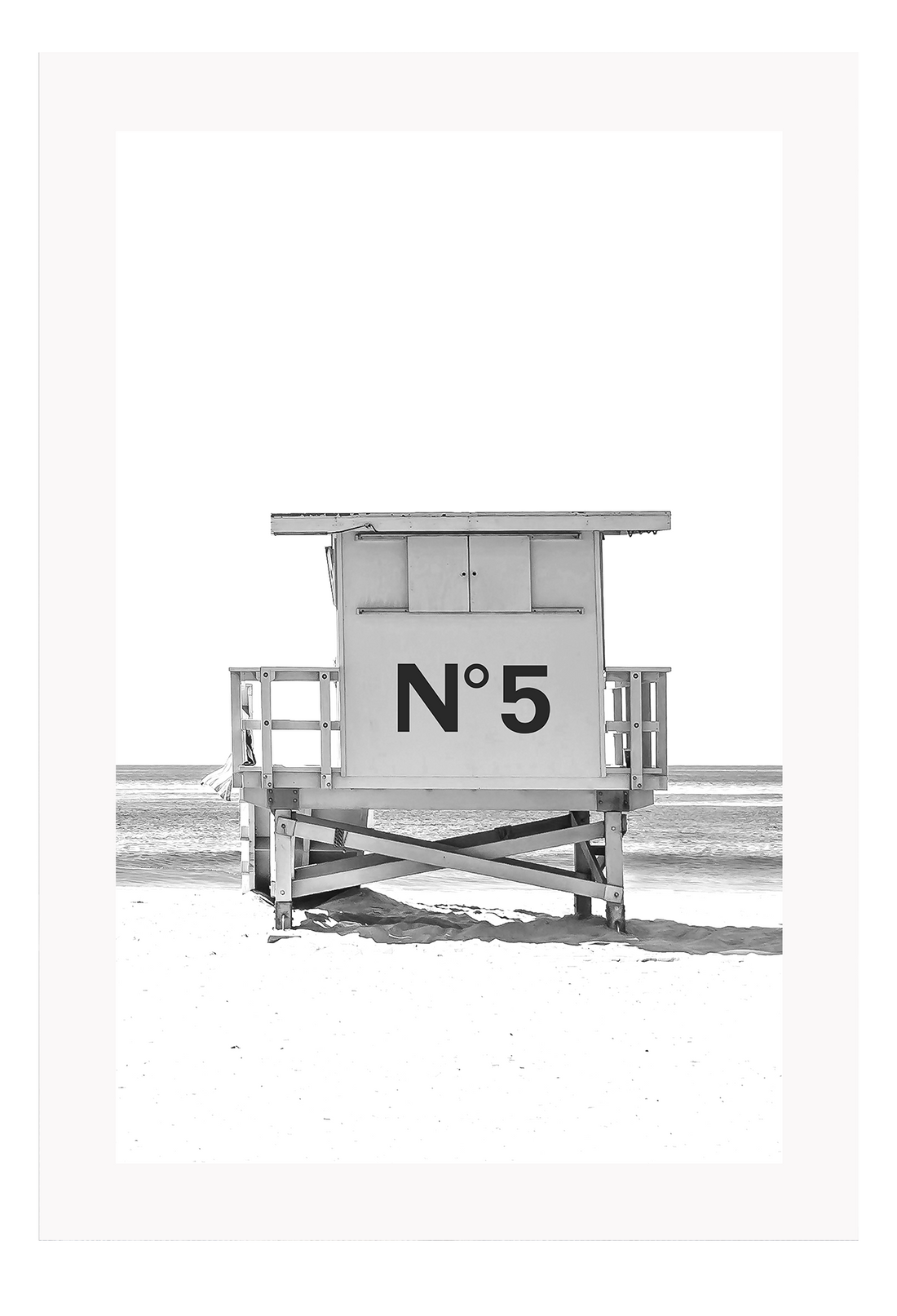 A black and white fashion wall art with black Chanel N5 fashion label on a beach cabin minimal