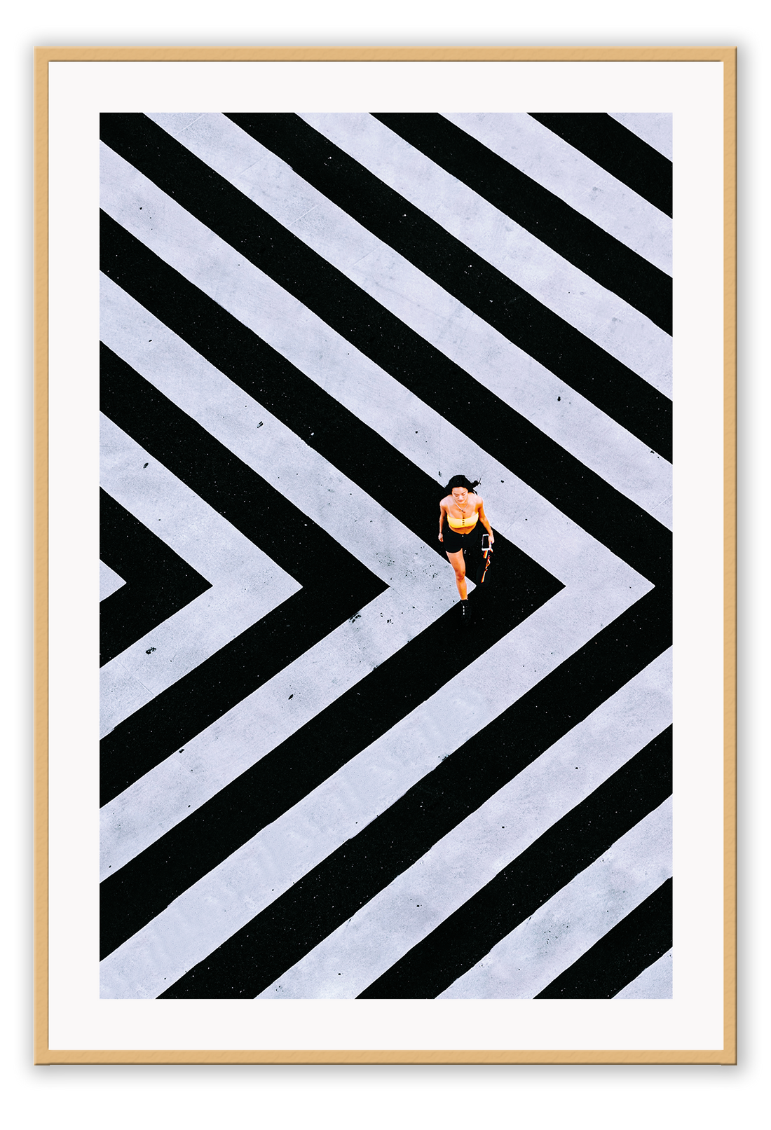 An urban wall art with an aerial view of a lady walking on black and white street crossing stripes