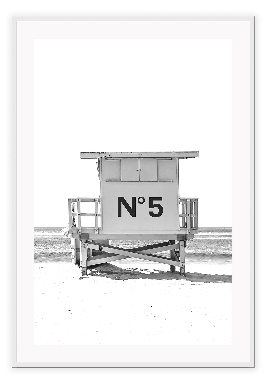 A black and white fashion wall art with black Chanel N5 fashion label on a beach cabin minimal