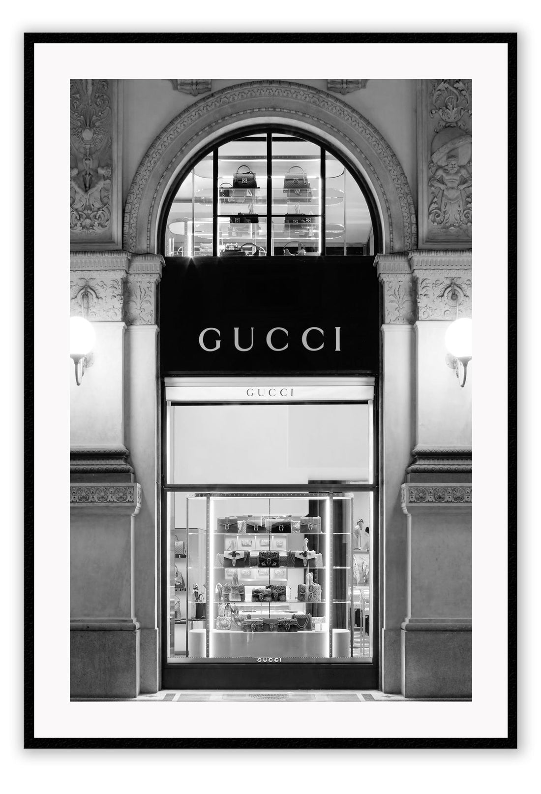 Fashion print with black and white Gucci shopfront faÔøΩade at night with ornamental lights and moulding. 