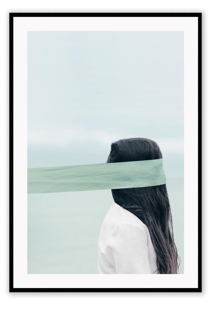 Photography of woman by the ocean wearing a blindfold with light blue tones and dark brown hair 