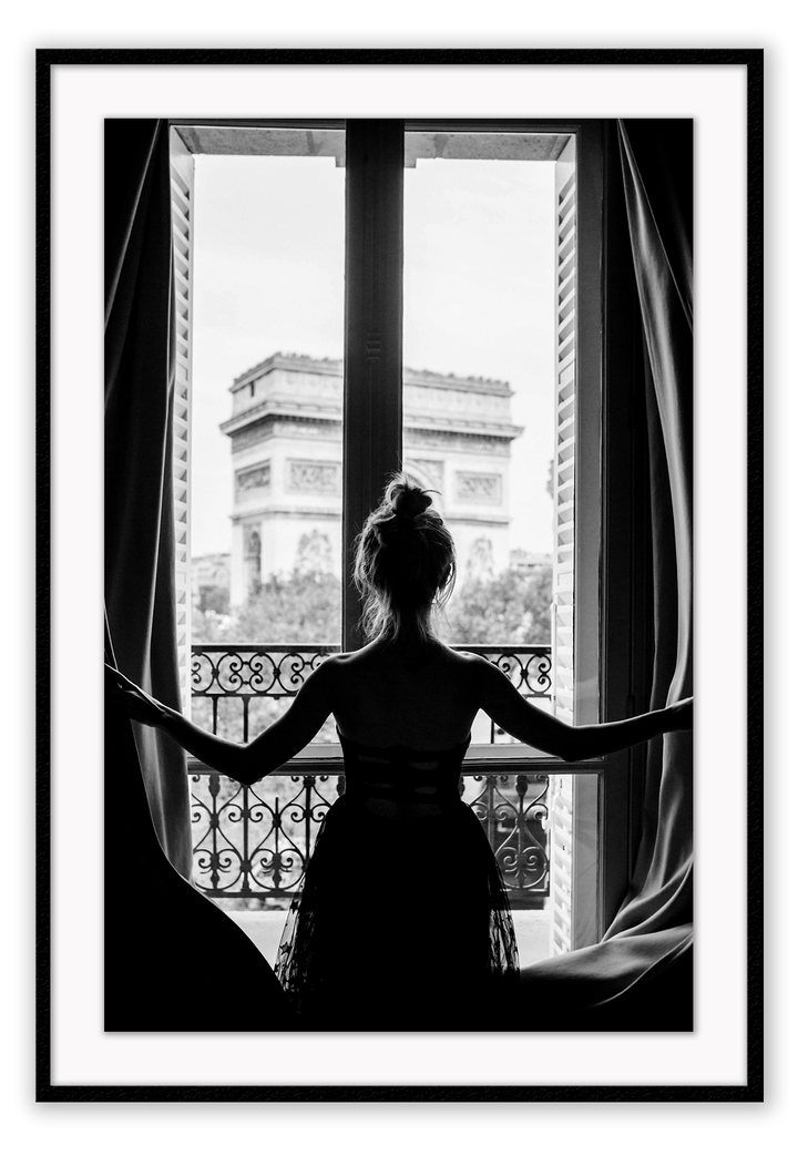 A black and white urban wall art with a girl looking out to the town from a vintage balcony in Paris. 