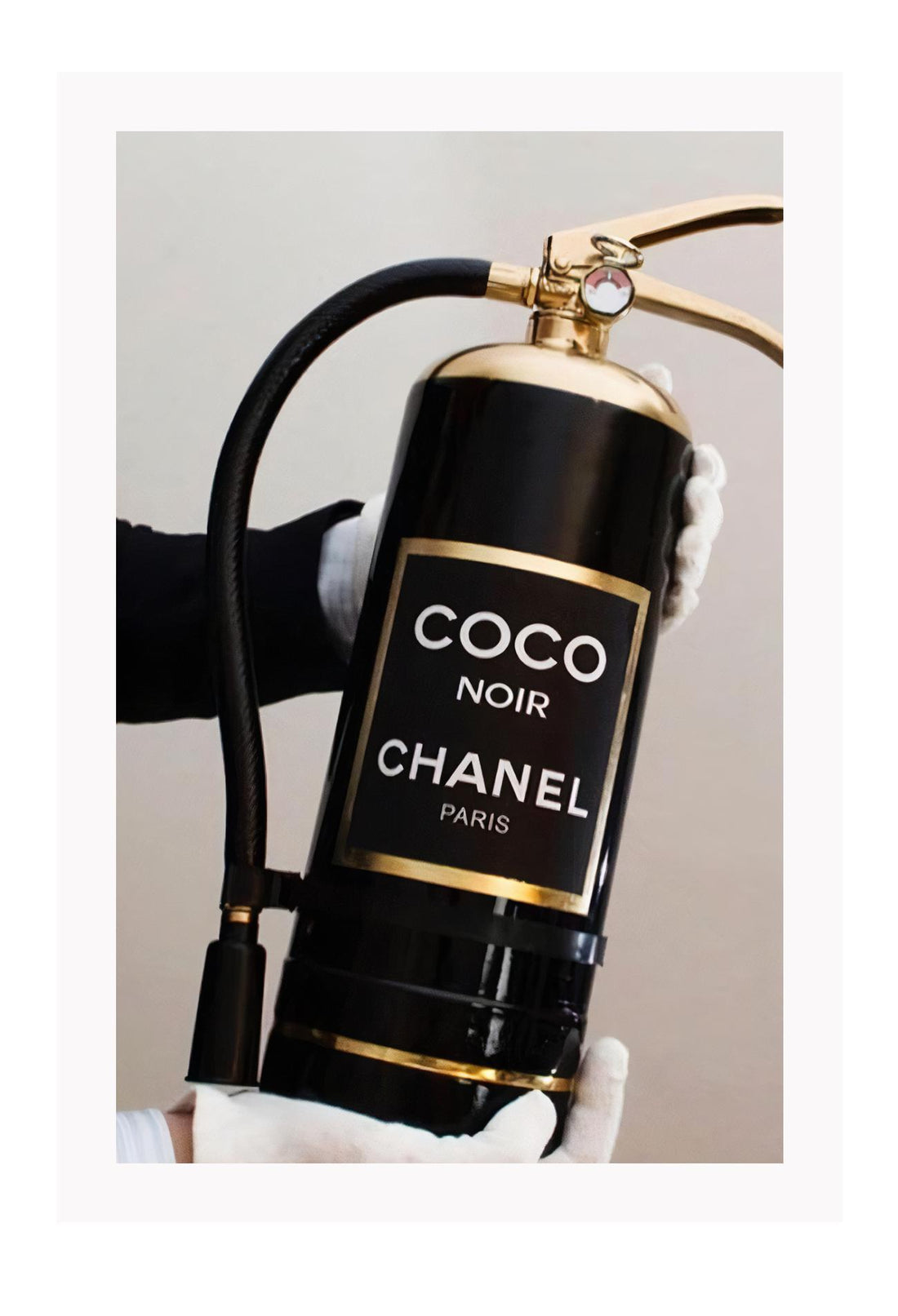 Gold, black and white fire fashion extinguisher with Chanel logo and hand with glove holding